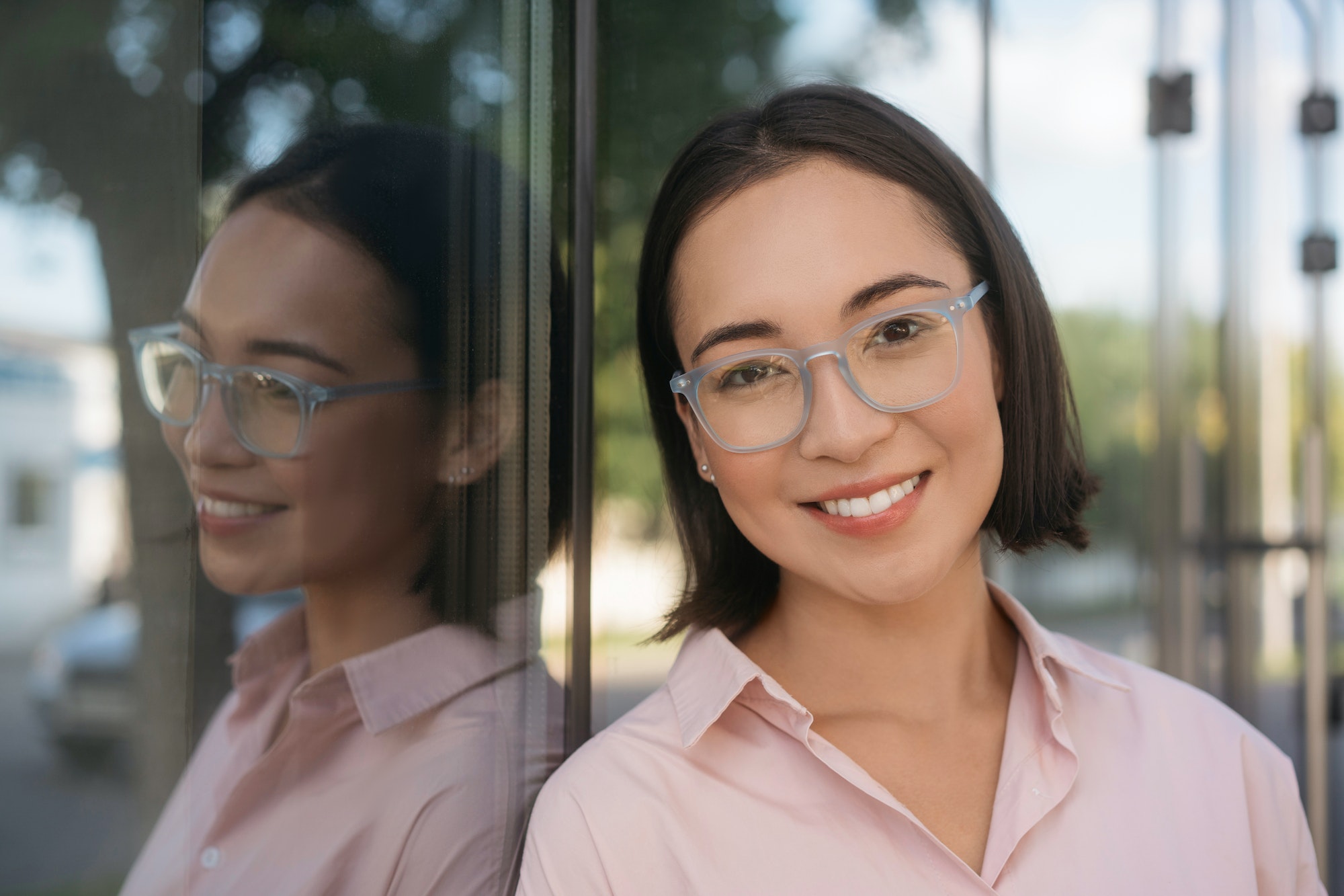 Beautiful asian woman wearing stylish eyeglasses looking at camera on the street