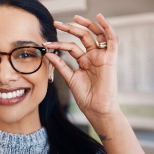 Shot of a young woman buying a new pair of glasses at an optometrist store